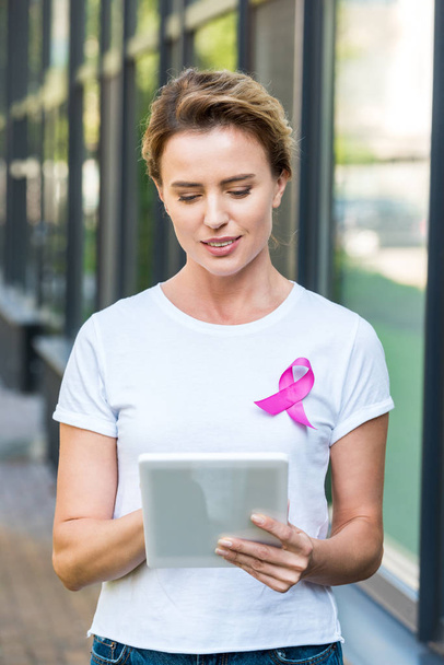 woman with pink ribbon on t-shirt using digital tablet, breast cancer awareness concept      - Fotó, kép