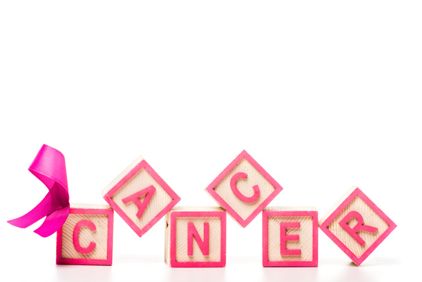 lähikuva vaaleanpunainen nauha ja puiset kuutiot sana syöpä eristetty valkoinen
 - Valokuva, kuva