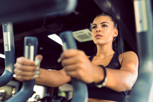 Jonge vrouw workout in fitnessruimte gezonde levensstijl - Foto, afbeelding