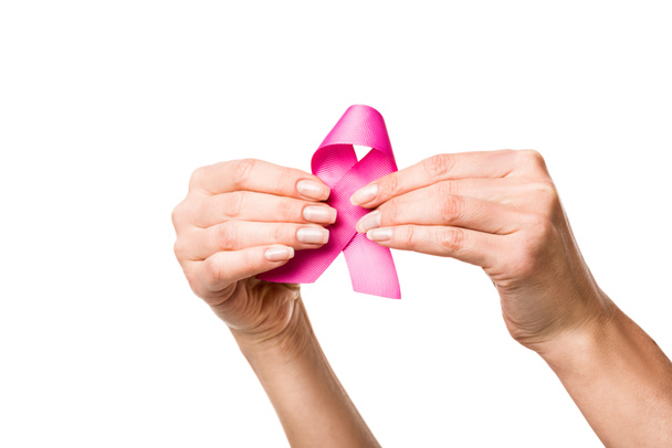close-up partial view of woman holding pink ribbon isolated on white, breast cancer awareness concept  - Foto, Bild