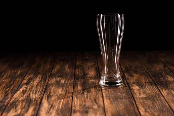 empty beer mug at wooden table on black background, minimalistic concept  - Foto, imagen