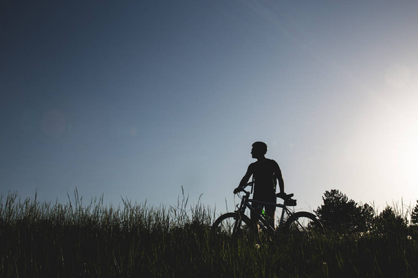 Silhueta de ciclista de montanha ao pôr-do-sol
 - Foto, Imagem