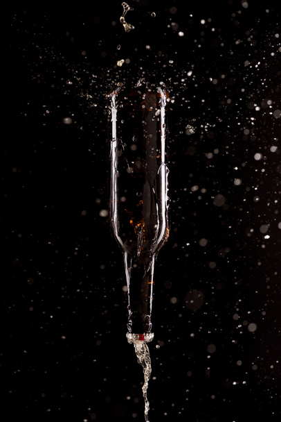 beer with splashes and bottle upside down falling isolated on black background - Foto, Bild