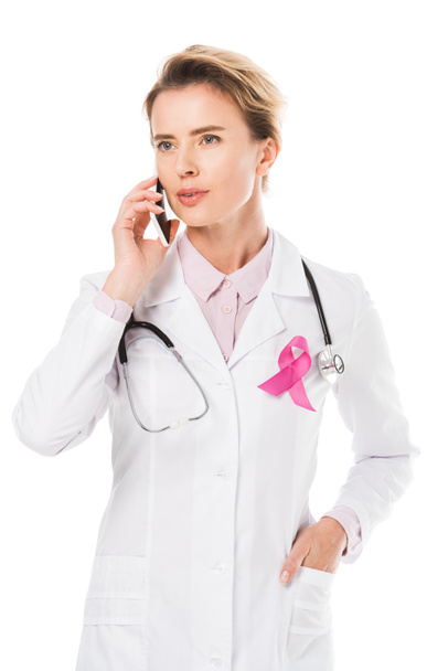 doctor with pink ribbon talking by smartphone isolated on white, breast cancer awareness concept - Photo, Image