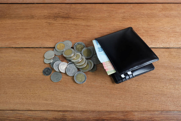 Fekete bőr pénztárca, pénzzel bankjegyek és érmék és fa padló - Fotó, kép