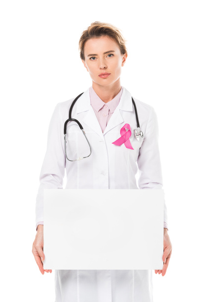 ピンクのリボンを空白のバナーを押しながらカメラ目線で医者が白、乳房癌意識概念に分離 - 写真・画像