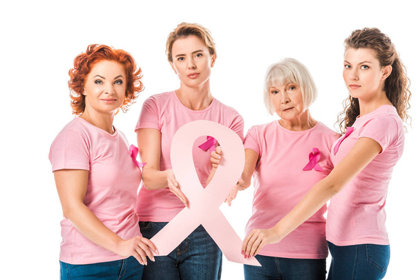 женщин в розовых футболках, держащих ленту информированности о раке груди и смотрящих на камеру, изолированную на белом
 - Фото, изображение