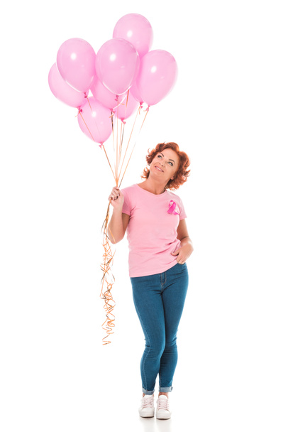 Lachende vrouw houdt van bos van roze ballonnen en opzoeken van geïsoleerde op wit, borst kanker concept - Foto, afbeelding