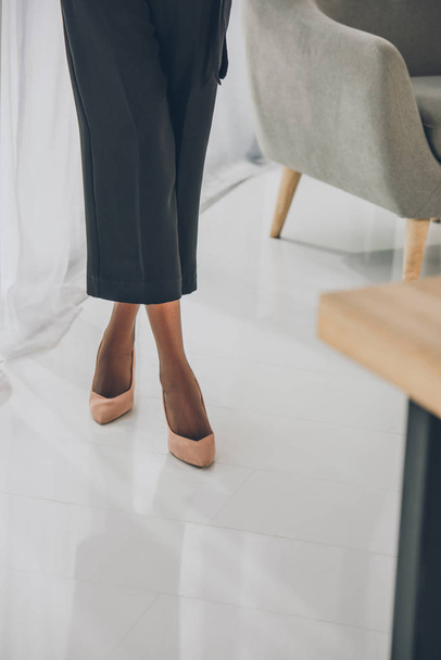 cropped image of stylish african american businesswoman on high heels standing in office - Фото, изображение