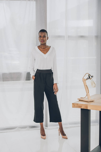 fashionable attractive african american businesswoman looking at camera in office - Fotoğraf, Görsel