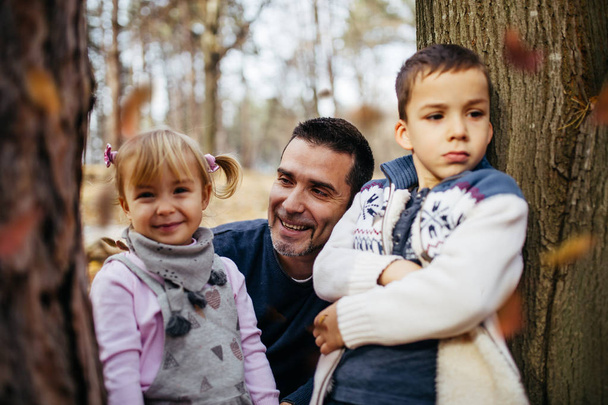 Happy young father with his son and doughter enjoying in autumn park. - Zdjęcie, obraz