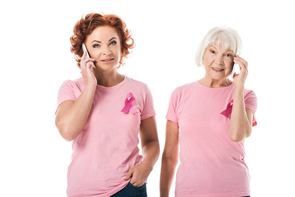 ピンク リボン スマート フォンで話して、ホワイト、乳房癌意識概念に分離カメラで笑顔の女性 - 写真・画像