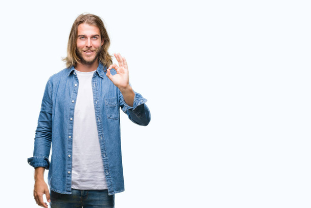 Young handsome man with long hair over isolated background smiling positive doing ok sign with hand and fingers. Successful expression. - Photo, Image