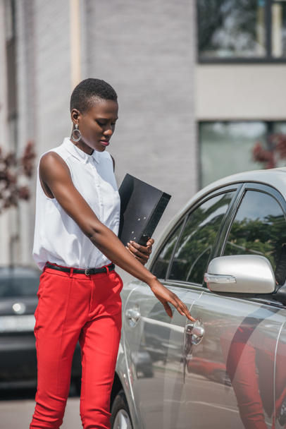 κομψή ελκυστική Αφρικανικός Αμερικανός επιχειρηματίας ανοίγοντας την πόρτα του ταξί στον δρόμο - Φωτογραφία, εικόνα