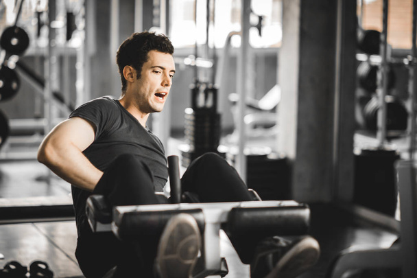 Fit handsome caucasian man sit up on machine in sportswear. Young man sit up exercise to strengthen their core abdominal muscles at fitness training in gym. Healthy, Sports, Lifestyle, Fitness concept - Foto, Imagem