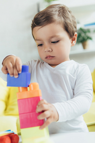 toddler playing with colorful constructor blocks at home - 写真・画像