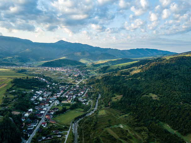 drone kép. a légi felvétel a vidéki hegyvidéki terület Szlovákia, falvak és Bölényfalu/Zuberec Habovka-ból fenti. drámai sunset át a hegyen, a felhők - Fotó, kép
