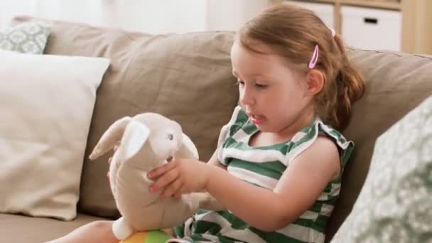 baby girl playing with toy rabbit at home - Footage, Video