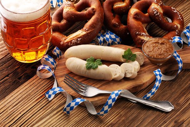Weißwurstfrühstück mit Würstchen, weicher Brezel und mildem Senf auf Holzbrett aus Deutschland. - Foto, Bild