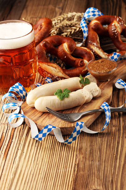 Beierse kalfsvlees worst ontbijt met worst, zachte krakeling en milde mosterd op een houten bord uit Duitsland. - Foto, afbeelding