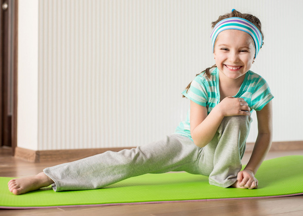 Little girl doing gymnastic exercises - Foto, imagen