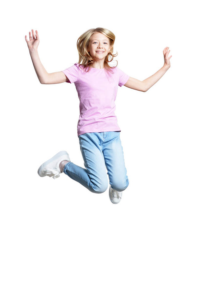 Full length portrait of cute girl in casual clothing jumping isolated on white background - Foto, immagini