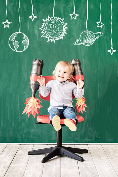 Happy child in class. Funny kid against chalkboard. Back to school. Education concept - 写真・画像