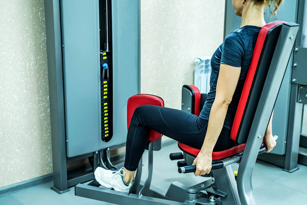 Vista lateral jovem mulher faz exercícios de perna no ginásio
 - Foto, Imagem