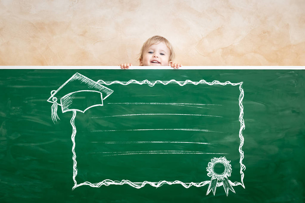 Happy child in class. Funny kid against chalkboard. Back to school. Education concept - Фото, изображение