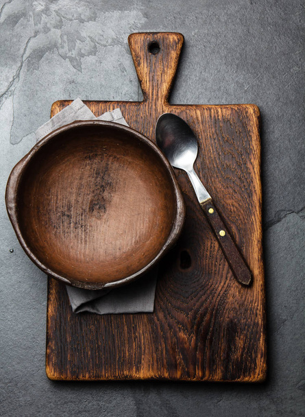 Cooking background. Vintage empty clay bowl on cutting boards, copy space. - 写真・画像