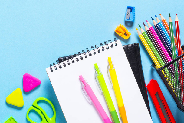 Iskolai és irodai kellékek, vagy helyhez kötött. Notebook, Jegyzettömb, toll és ceruza a kék felülnézet. - Fotó, kép