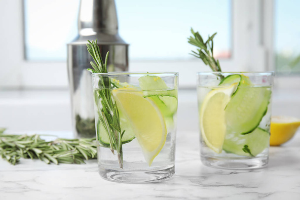 Refreshing lemon cocktail with rosemary on marble table - Fotografie, Obrázek