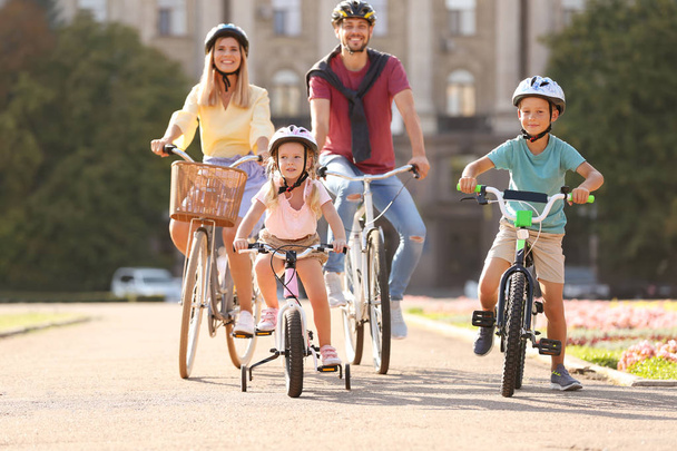 Happy family riding bicycles outdoors on summer day - Photo, Image