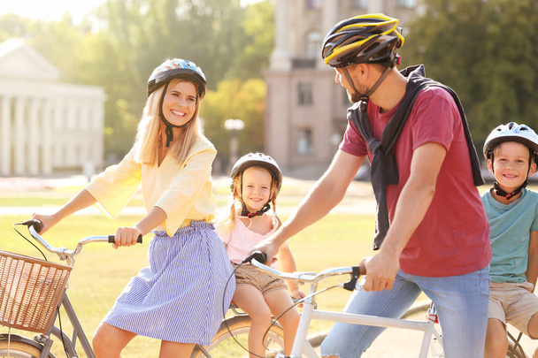 Happy family riding bicycles outdoors on summer day - Фото, зображення