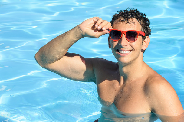 Summer man in pool - Foto, afbeelding