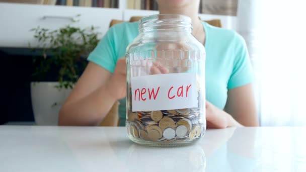 Genç kadının cam kavanoza para atma kavramsal 4 k görüntüleri. Çerçeve içinde oyuncak araba sürmek - Video, Çekim