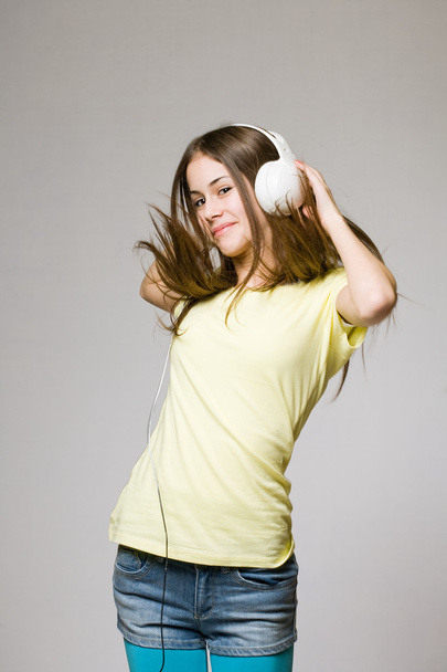 Cute teen dancing in headphones. - Foto, afbeelding