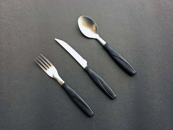 Fork, knife and spoon on the dark background - Foto, immagini