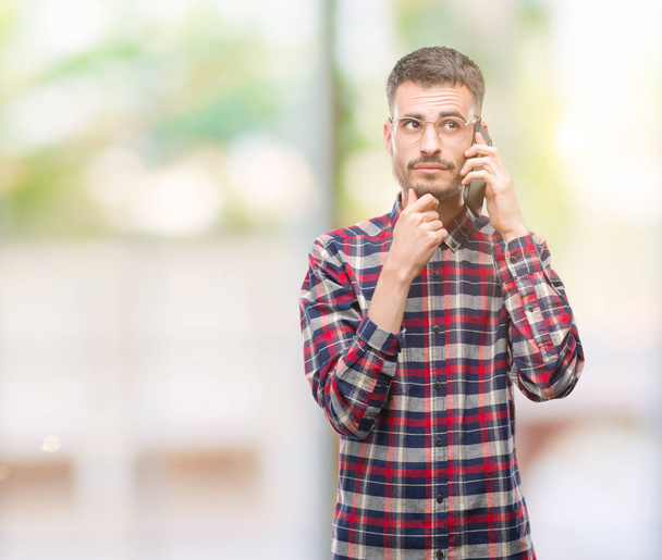 Young hipster adult man talking on the phone serious face thinking about question, very confused idea - Foto, Imagem