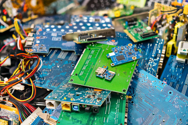 E-waste heap from discarded laptop parts. Connectors, PCB, notebook cards. Colorful blurry background from PC components. Idea of electronics industry, eco, sorting and disposal of electronic waste. - Valokuva, kuva