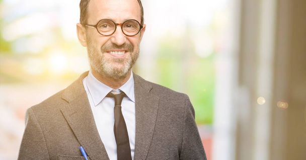 Δάσκαλος ο άνθρωπος χρησιμοποιώντας γυαλιά αυτοπεποίθηση και χαρούμενοι με ένα μεγάλο φυσικό χαμόγελο γελώντας - Φωτογραφία, εικόνα