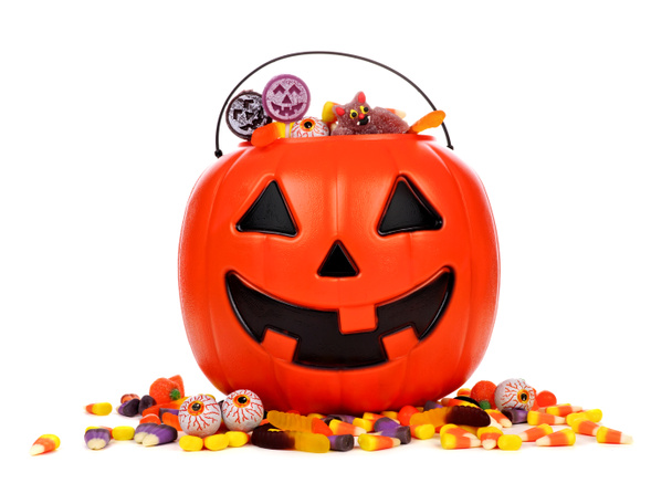 Black Halloween Jack o Lantern candy collector with scattered candy over a white background - Photo, Image