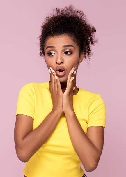 Excited african american woman looking at camera, posing on pink pastel background. - 写真・画像