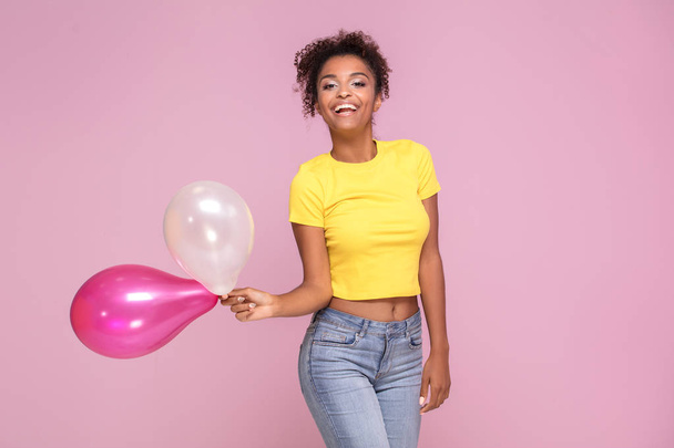 Excited african american woman smiling, looking at camera, posing on pink pastel background. - Photo, image