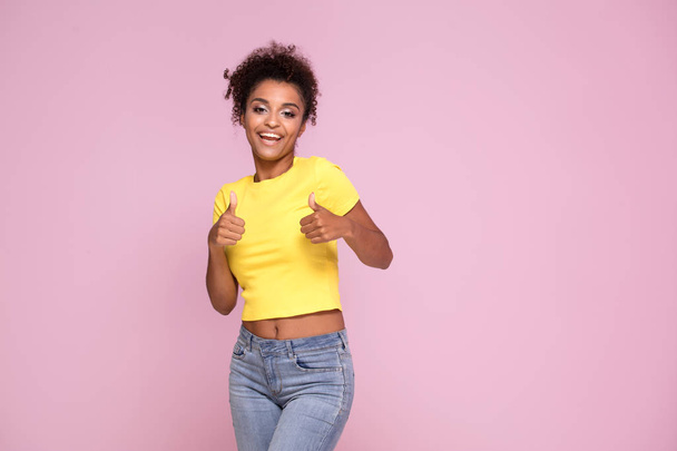 Excited african american woman smiling, looking at camera, posing on pink pastel background. - Photo, Image