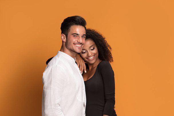 Beautiful mixed race couple posing together in studio. Men looking at camera. - Фото, изображение