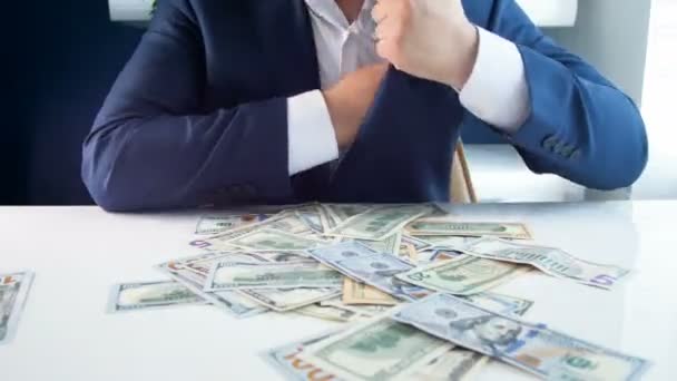 4k video de codicioso empresario agarrando montón de dinero y llenando sus bolsillos
 - Imágenes, Vídeo