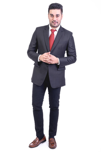 Businessman isolated in white background. Handsome young indian businessman in suit portrait, interlock fingers. Full length shot. - Foto, afbeelding