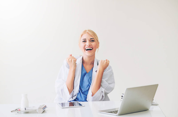 Happy successful woman doctor feels delightful in hospital or healthcare institute while working on medical report at office table. Success concept. - Φωτογραφία, εικόνα
