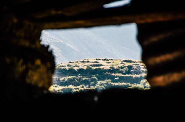 Näkymä vuorelle vanhan ikkunan läpi
 - Valokuva, kuva